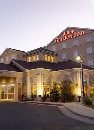 A large hotel with a sign on the front with Hilton Garden Inn in the background