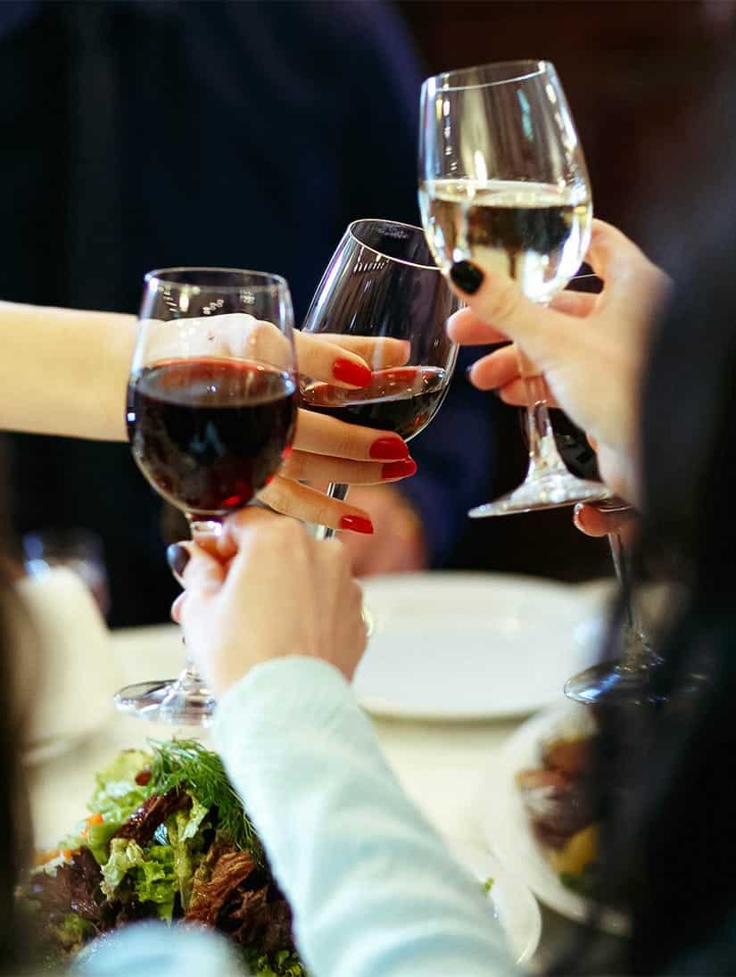 A group of people holding wine glasses