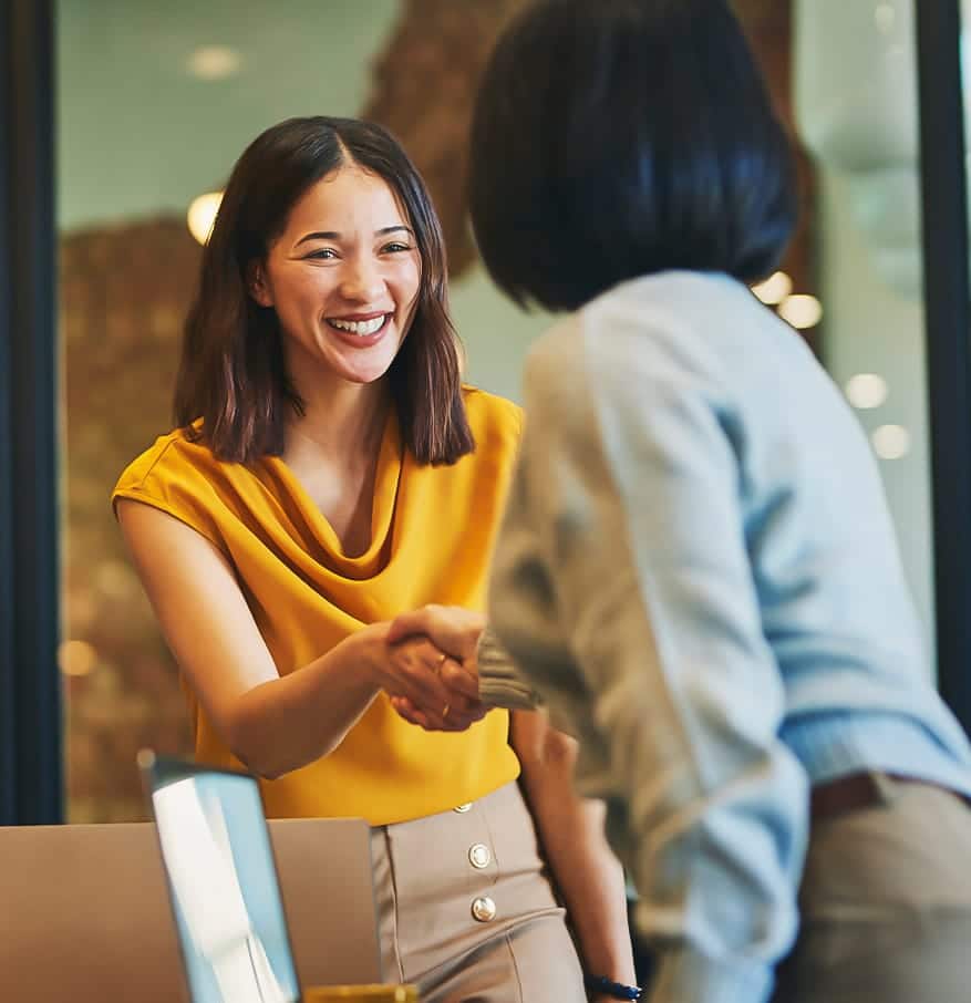 A woman shaking hands with another woman