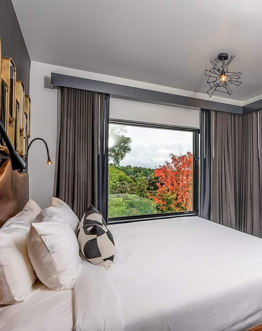 A bed with a window and a view of trees
