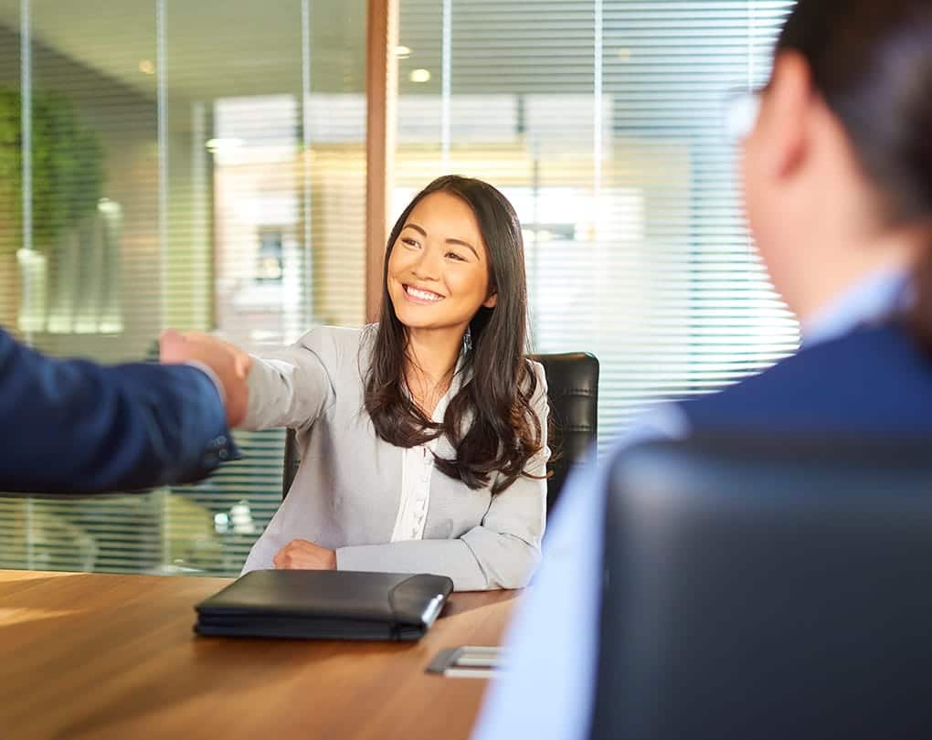 A woman shaking hands with a man