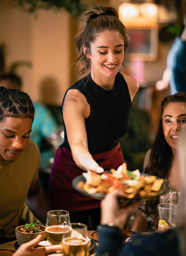 A woman serving food to a group of people