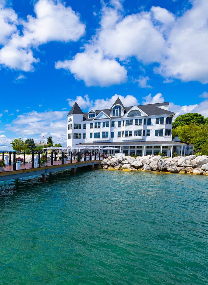 A large white building with a dock over water