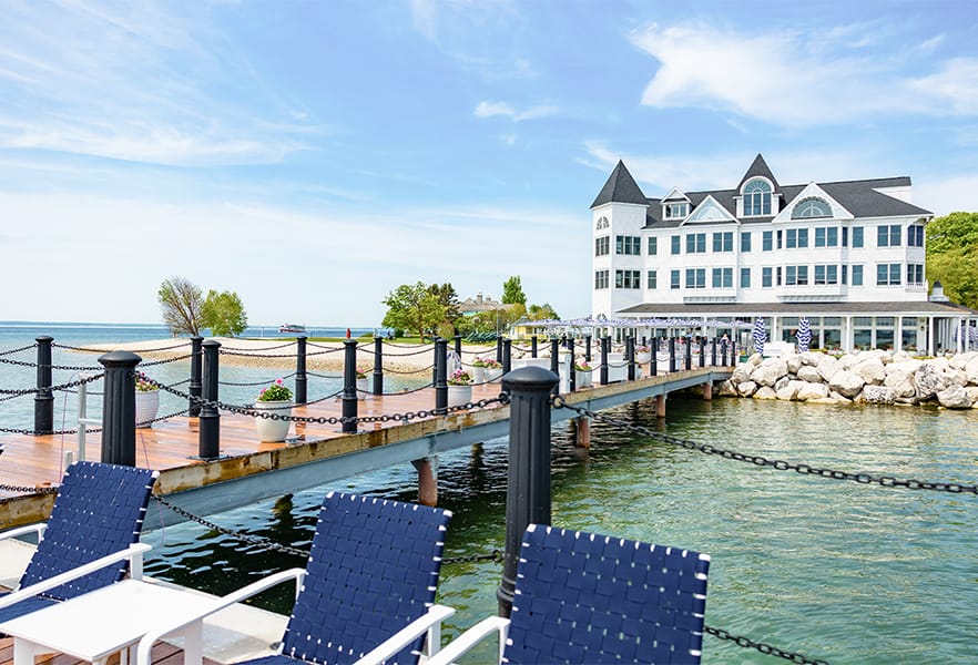 A dock with chairs and a building in the background