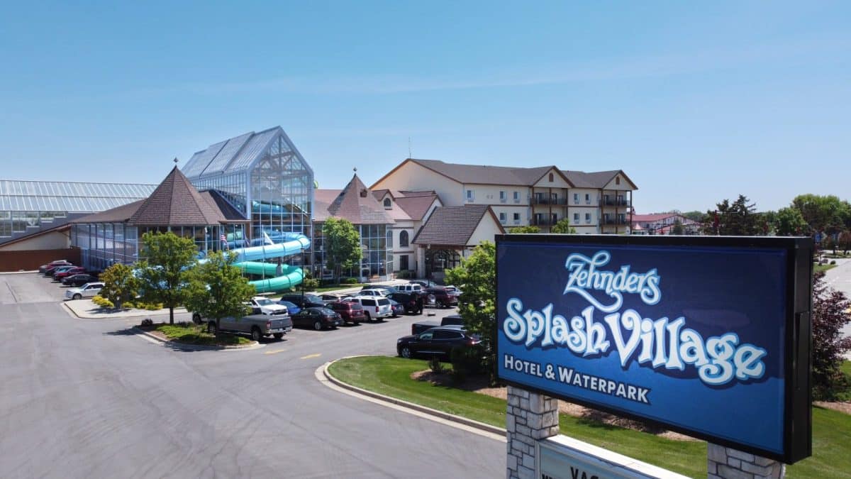 A sign with a water slide in the background